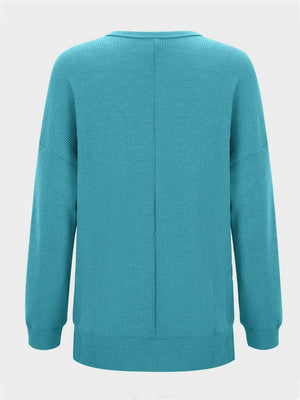 Waffle knit crewneck top in pastel blue with relaxed fit and long sleeves.