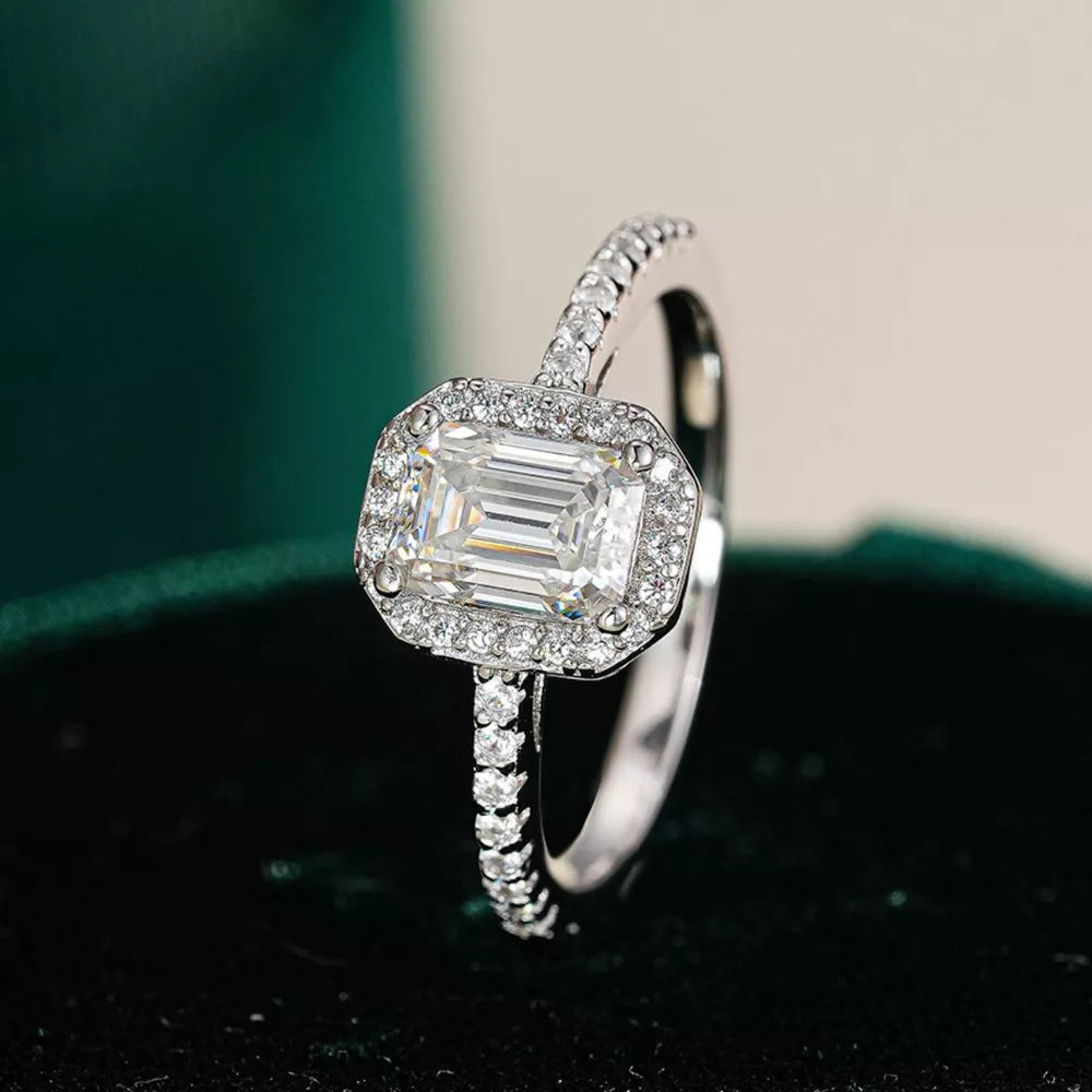 Radiant moissanite engagement ring in silver with emerald-cut center stone and diamond halo.