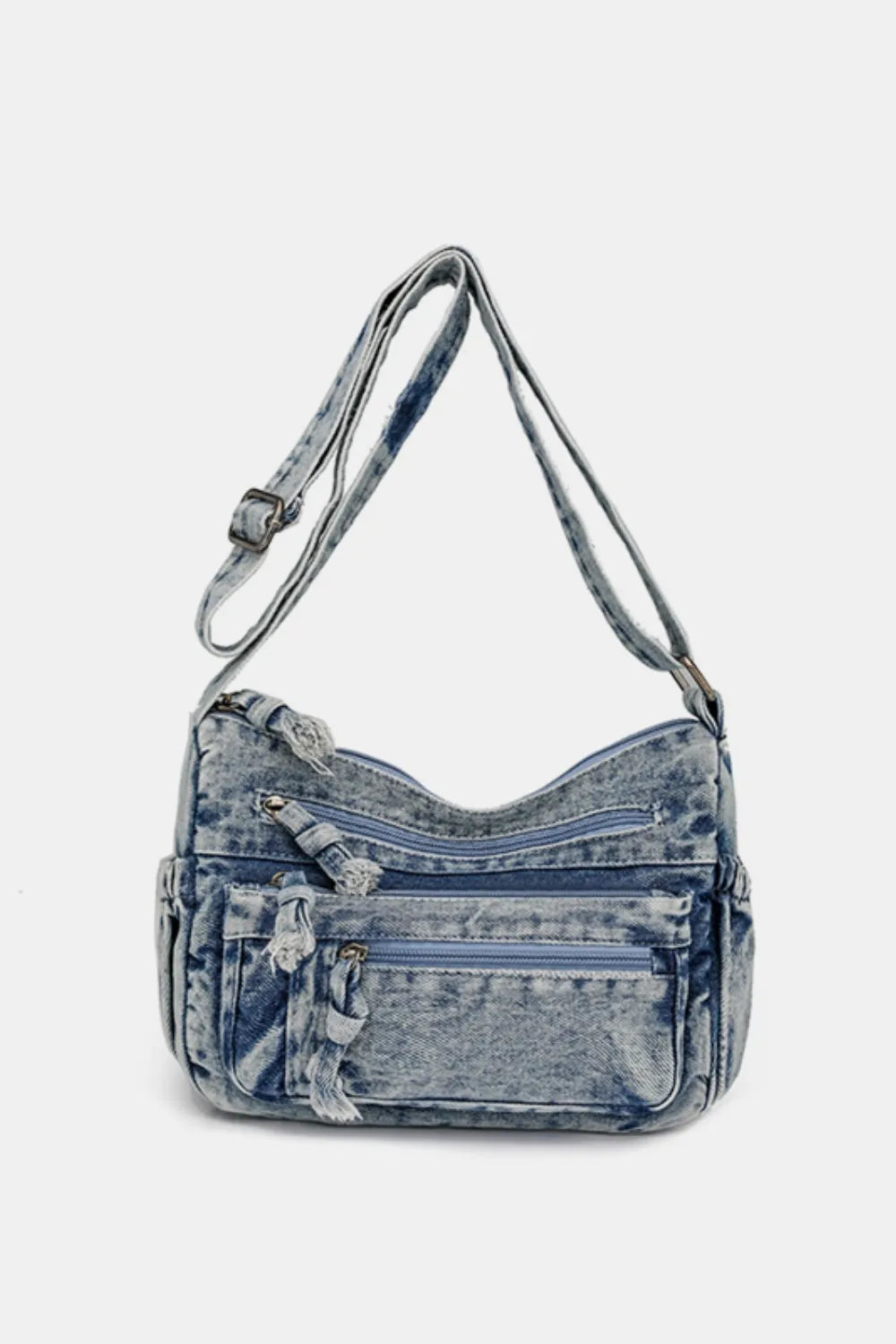 Acid wash denim crossbody bag with multiple zippered pockets and adjustable strap.