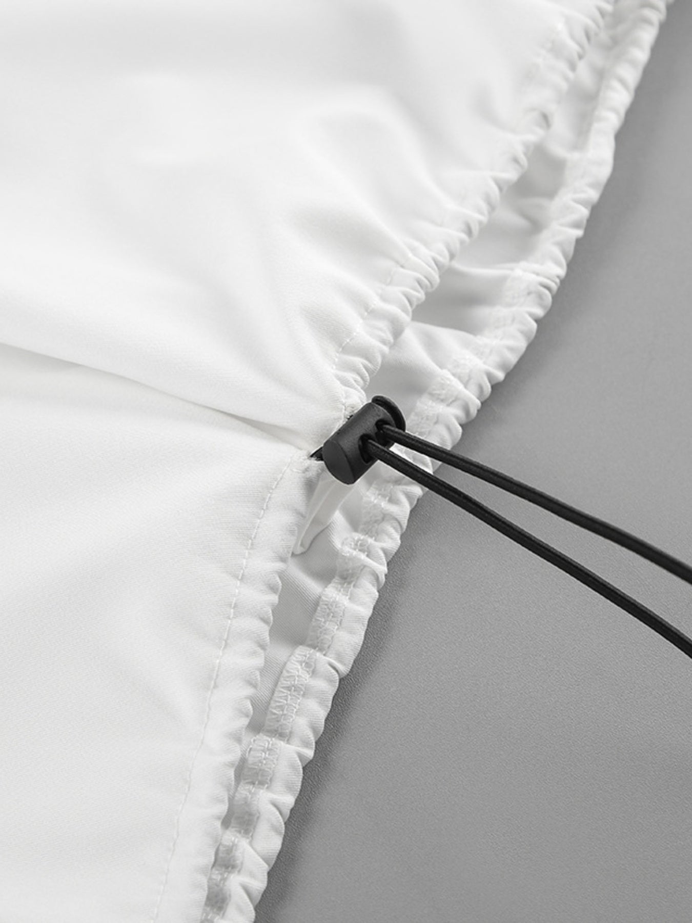 White two-piece set detail with drawstring and snap closure