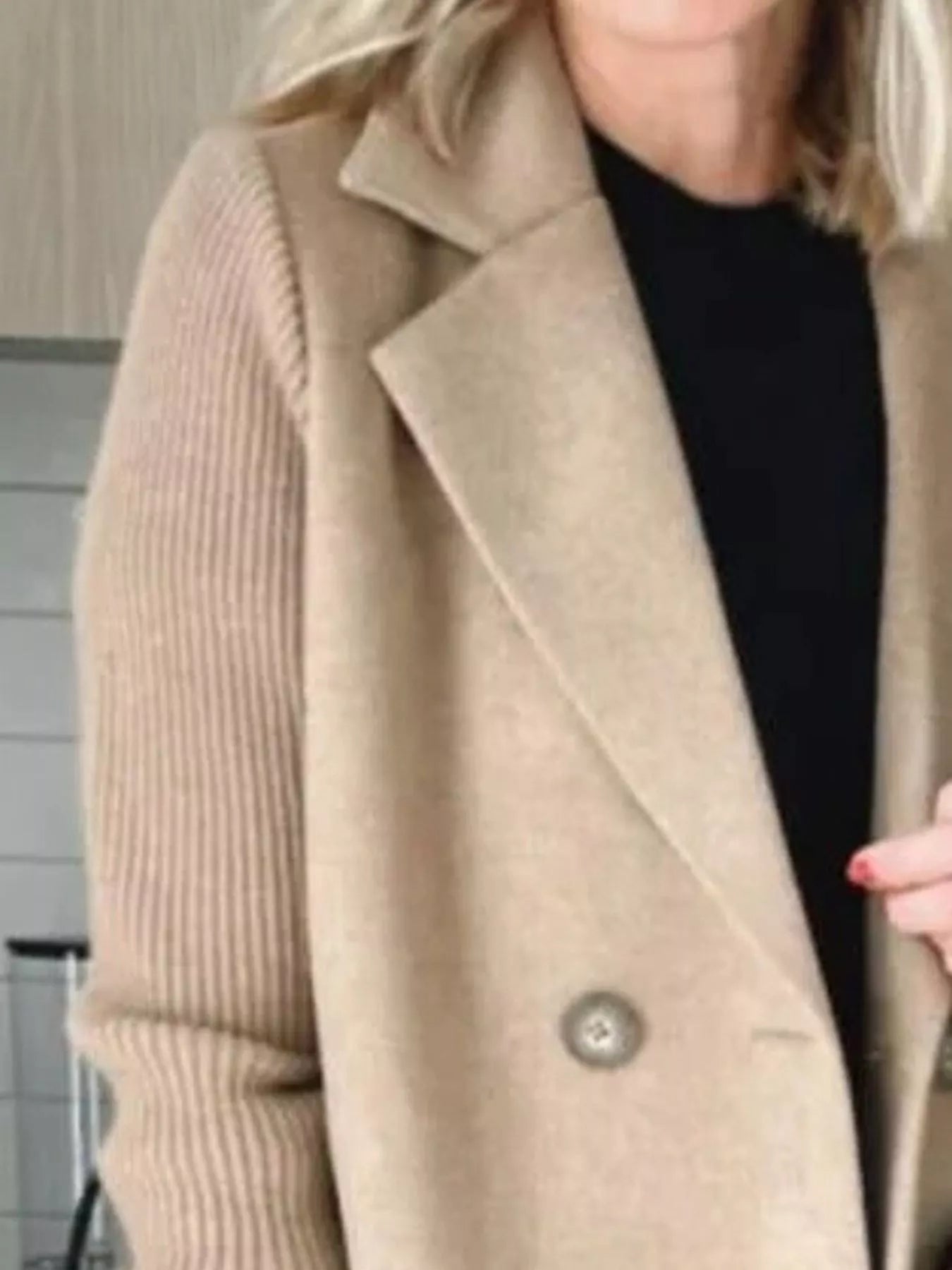 Double-breasted beige wool blend blazer with ribbed knit sleeves and button detail.