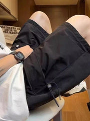 Black lightweight cargo shorts with drawstring detail and pockets, worn by a man.