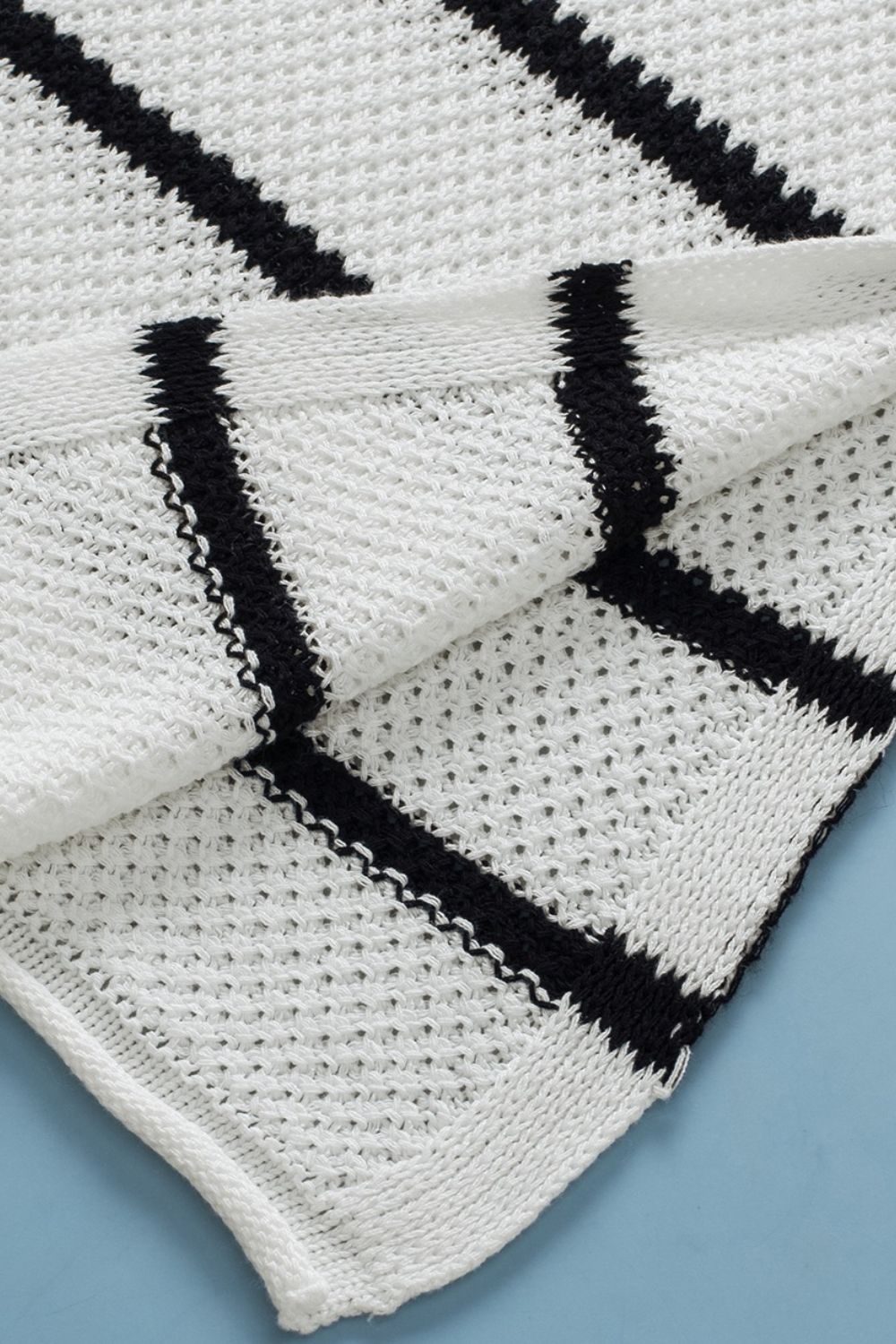 White and black stripe knit pullover sweater with open knit detail.