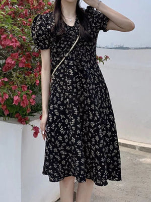 Black botanical print midi dress with puff sleeves and a-line cut.