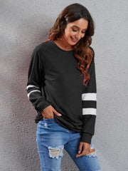 Black sweatshirt dress with raglan sleeves and white varsity stripes on the arms.