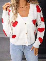 White knit cardigan with red heart pattern, button front, V-neck, long sleeves.