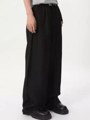 Black relaxed wide-leg pleated trousers with a loose fit and visible stitching detail.