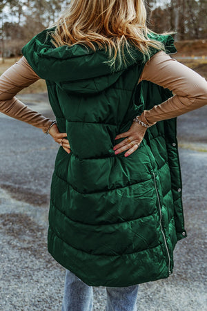 Longline hooded puffer vest in green with horizontal quilting and a full zip closure.