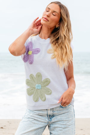 White knit sleeveless top with embroidered floral appliques in purple, green, and tan.