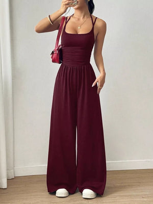 Burgundy ruched wide-leg jumpsuit with spaghetti straps and square neckline.