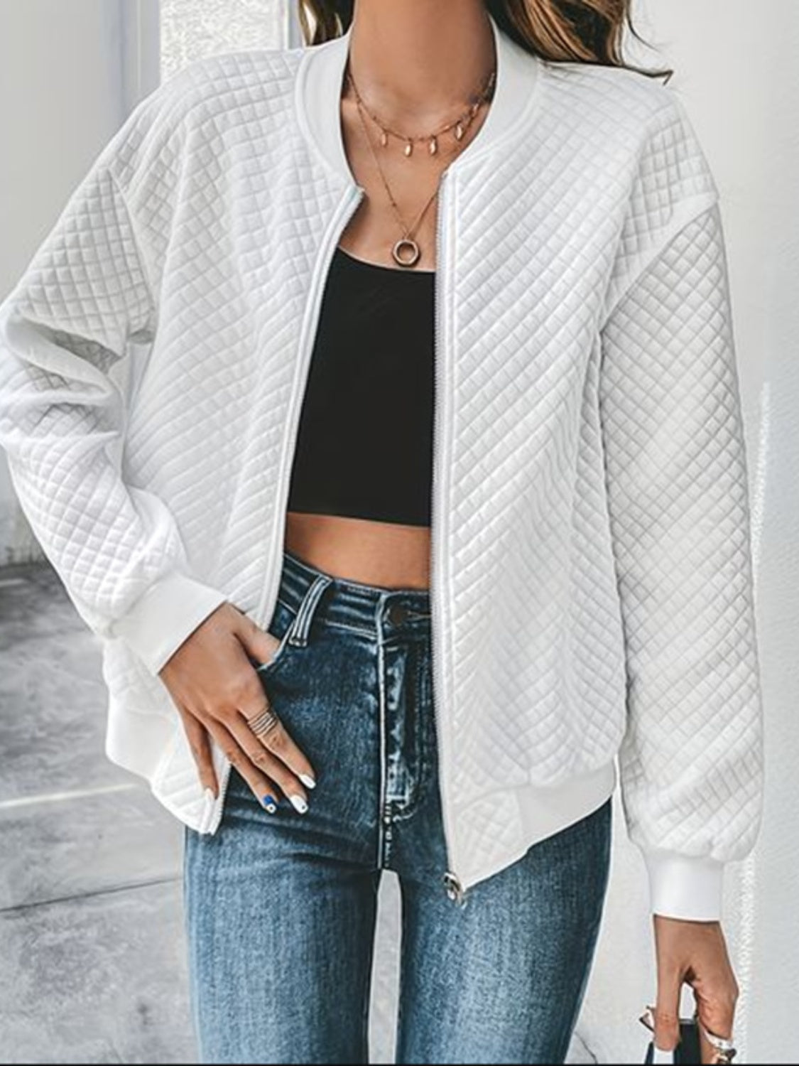 White diamond quilted bomber jacket with zip front and ribbed cuffs.