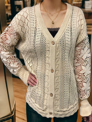Tan knit cardigan with lace sleeves, V-neck, and button front.