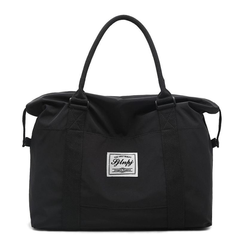 Black large capacity travel duffel bag with top handles and a front label.
