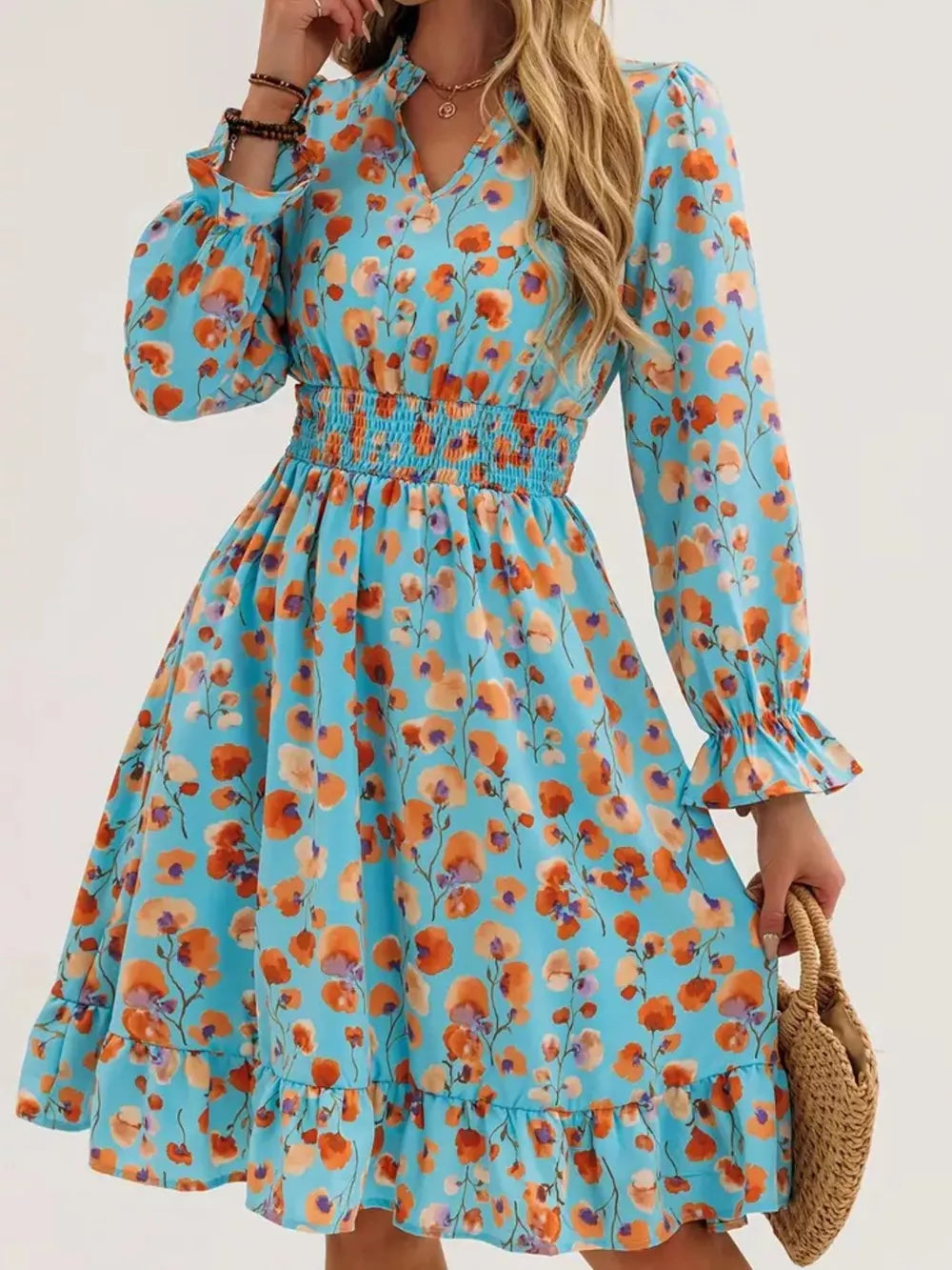 Pastel blue floral smocked dress with ruffled hem and cuffs.