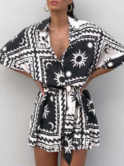 Black celestial print wrap romper with short sleeves and a tie waist.