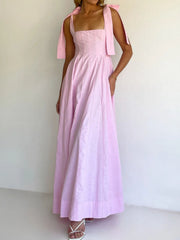 Pink bow-tie shoulder maxi dress with square neckline and full skirt.