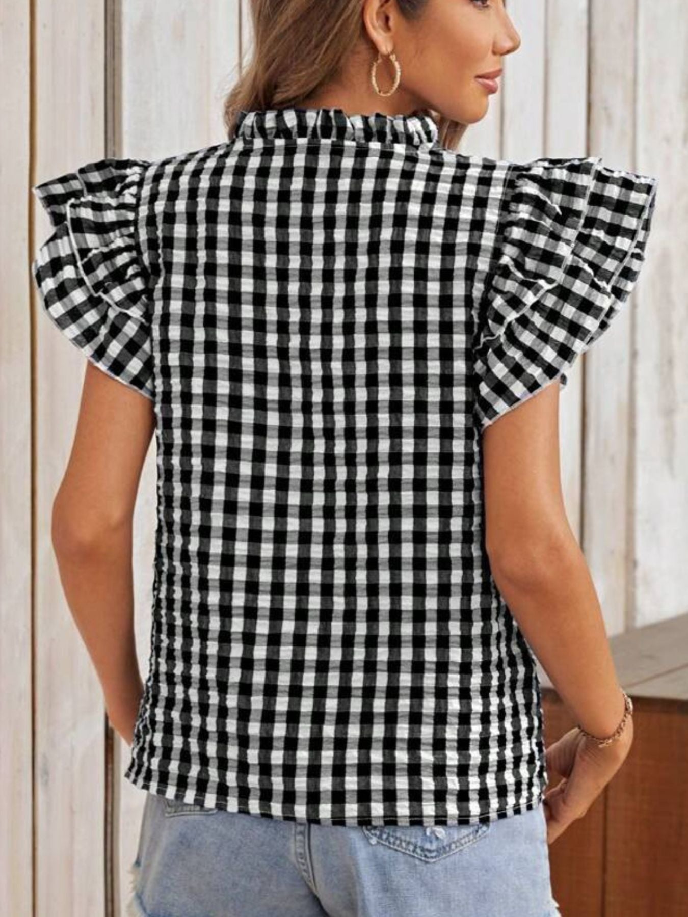 Black and white gingham blouse with ruffle sleeves and mock neck.