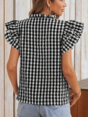 Black and white gingham blouse with ruffle sleeves and mock neck.
