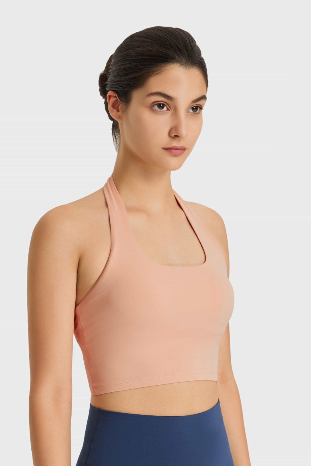 Nude halter neck sports bra with ruched back detail and square neckline.