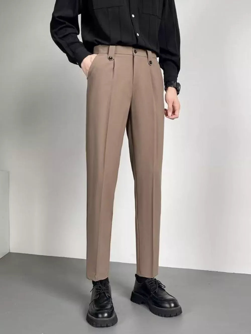Men's taupe ankle-length slim fit trousers with double button waist detail.