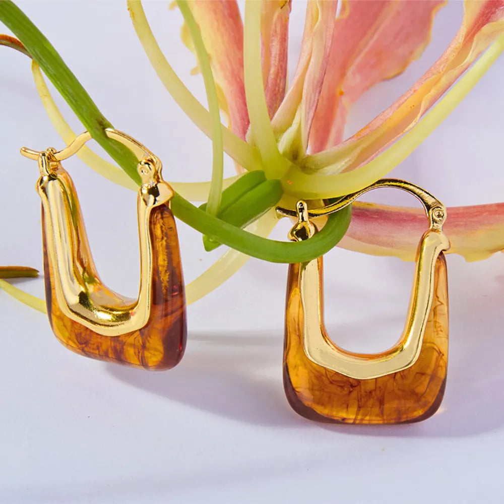 Gold geometric hoop earrings with amber resin detail