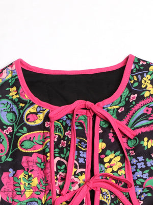 Paisley quilted jacket with tie closure in black with pink trim and floral print.