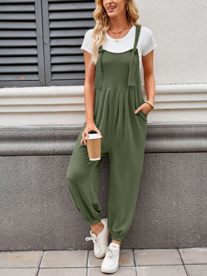Olive green corduroy overalls with barrel leg and tie straps, worn with a white tee.