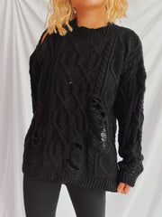 Black distressed cable knit sweater with ripped details and cut-out shoulder.