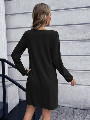 Black button-down mini dress with long sleeves and A-line cut.