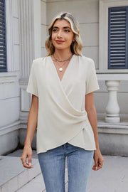Cream draped front short sleeve blouse with a V-neckline.