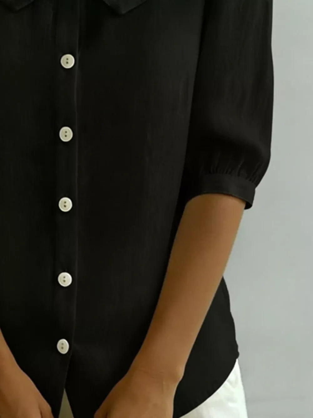 Black button-down shirt with Peter Pan collar and puff sleeves.