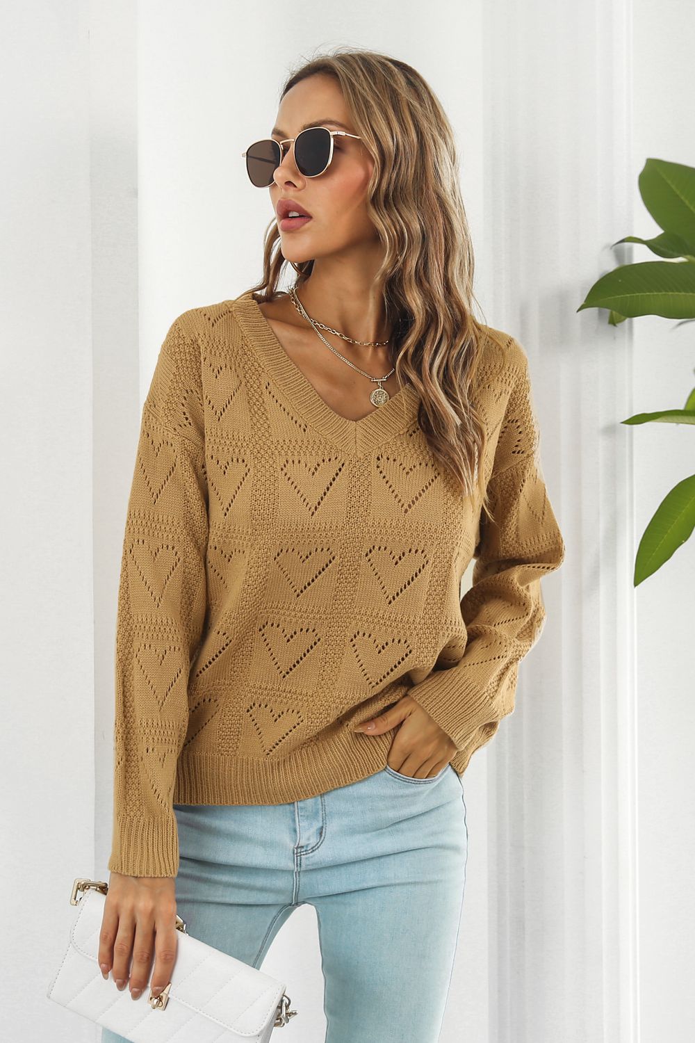 Camel v-neck knit pullover sweater with allover heart stitch pattern and long sleeves.