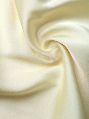 Lace-trimmed midi slip dress in pale yellow satin with a side slit detail.
