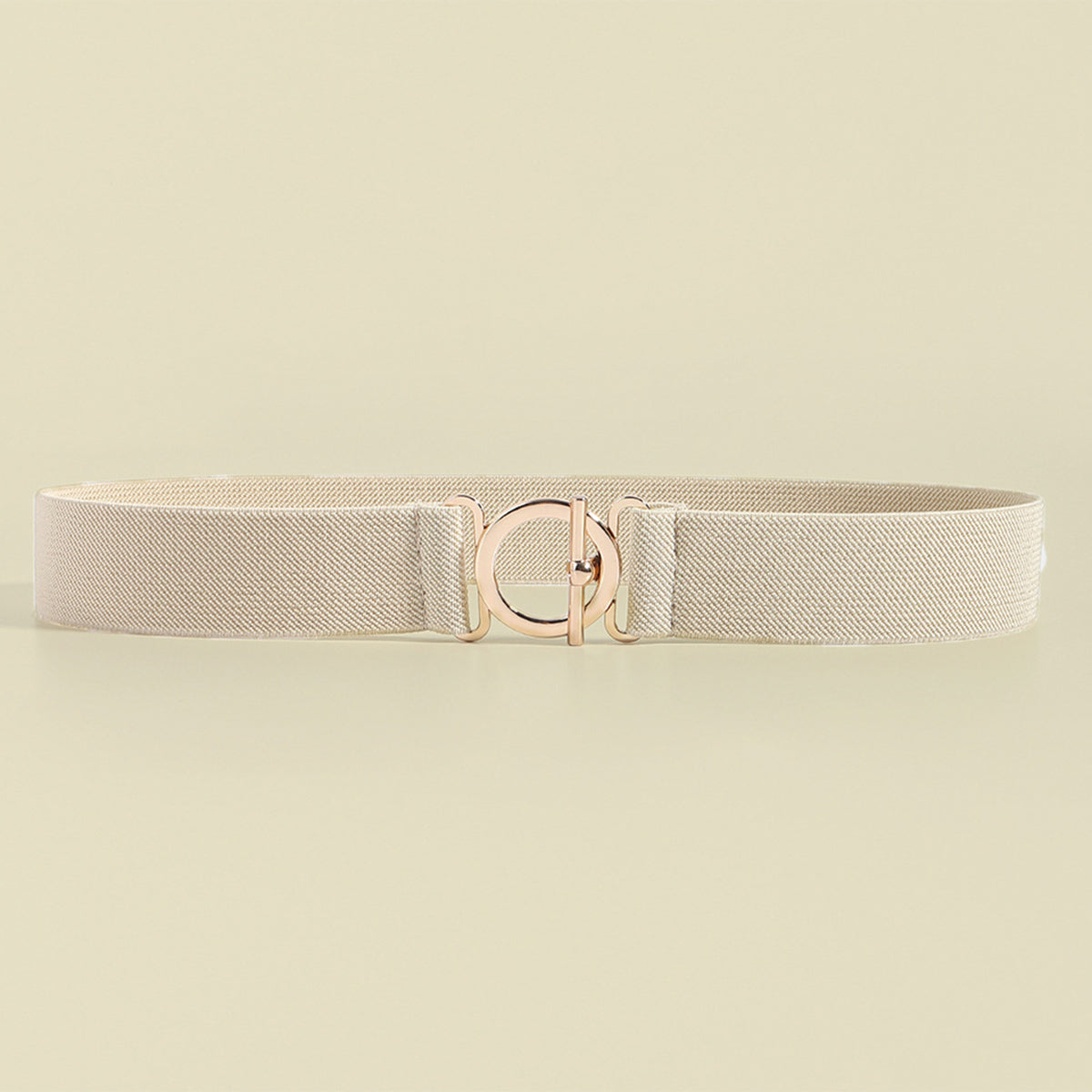 Elasticated belt in ivory with a rose gold circle buckle and toggle closure.