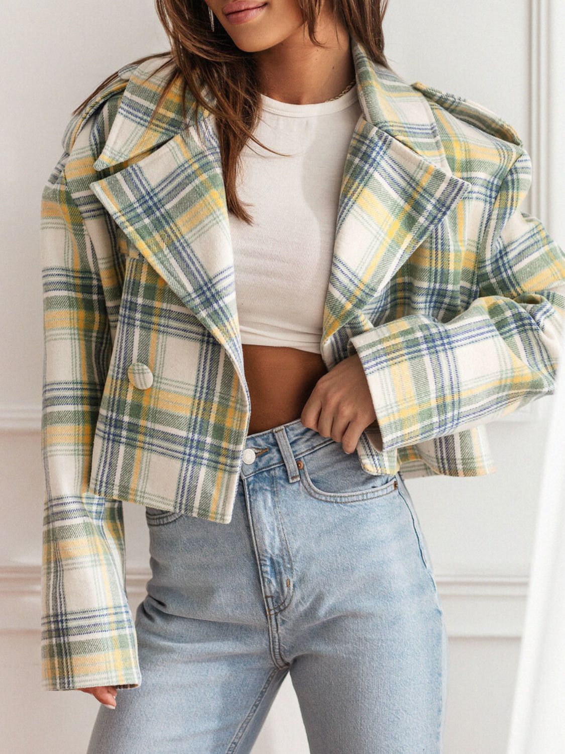 Boxy plaid cropped blazer in cream with yellow, green, and blue plaid. Features a double-breasted front and wide lapels.