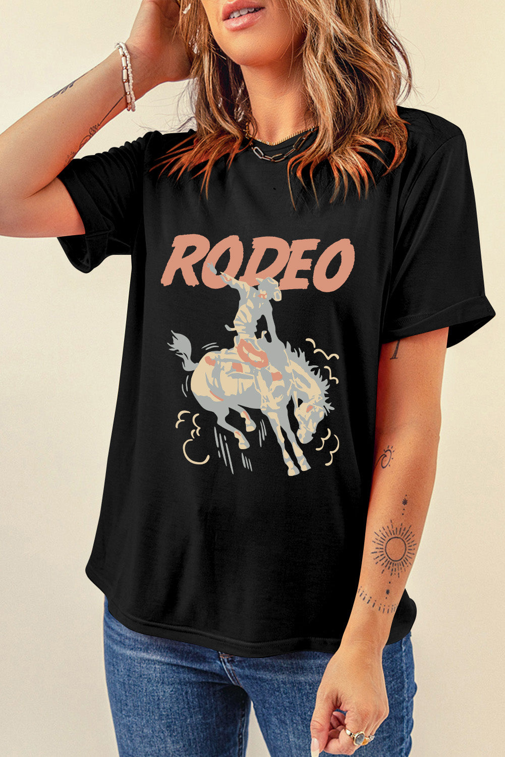 Black rodeo graphic tee with rolled sleeves and a distressed cowboy on a bucking horse design.