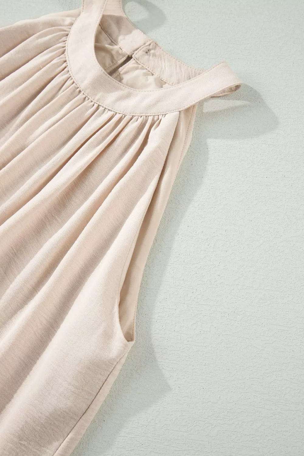 Beige halter maxi dress with gathered neckline and lace hem detail.