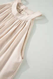 Beige halter maxi dress with gathered neckline and lace hem detail.