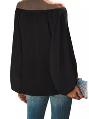 Black off-shoulder maternity blouse with balloon sleeves, styled with jeans and a clutch.