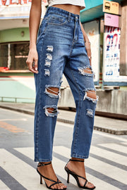 Distressed straight leg denim jeans in medium wash with ripped details.