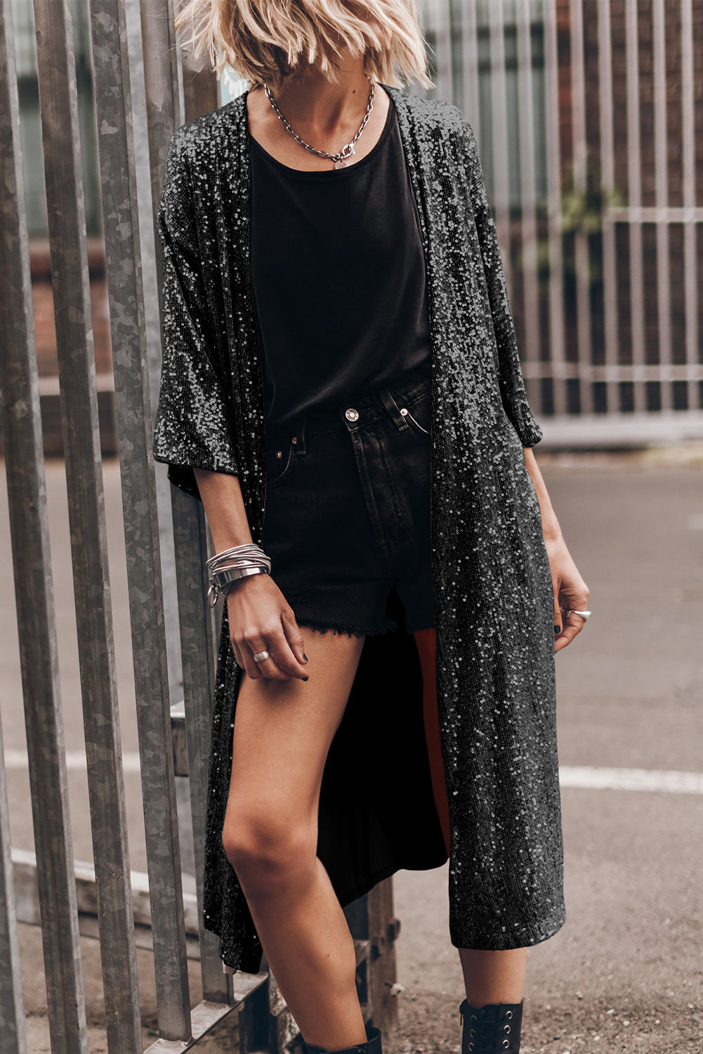 Black sequin kimono jacket with open front and wide sleeves, worn over black top and shorts.