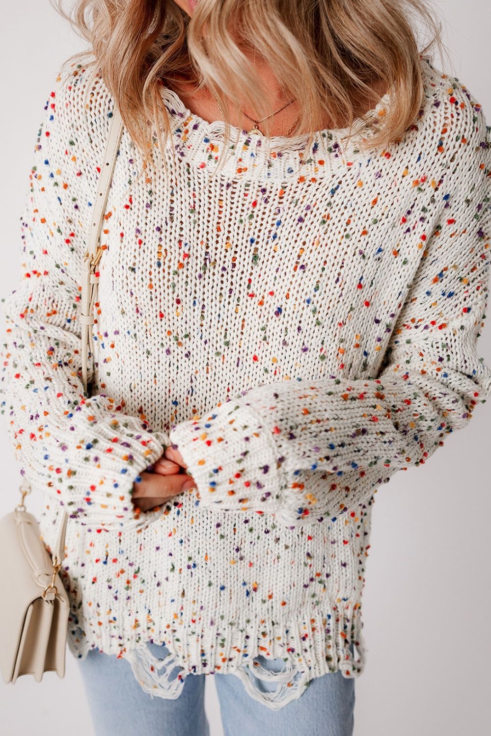 Confetti knit sweater in white with colorful flecks and distressed hem.