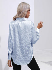 Light blue satin leopard print blouse with button cuffs and collared neckline.