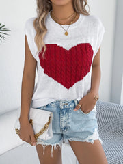 White cable knit sweater vest with red cable knit heart graphic, sleeveless.