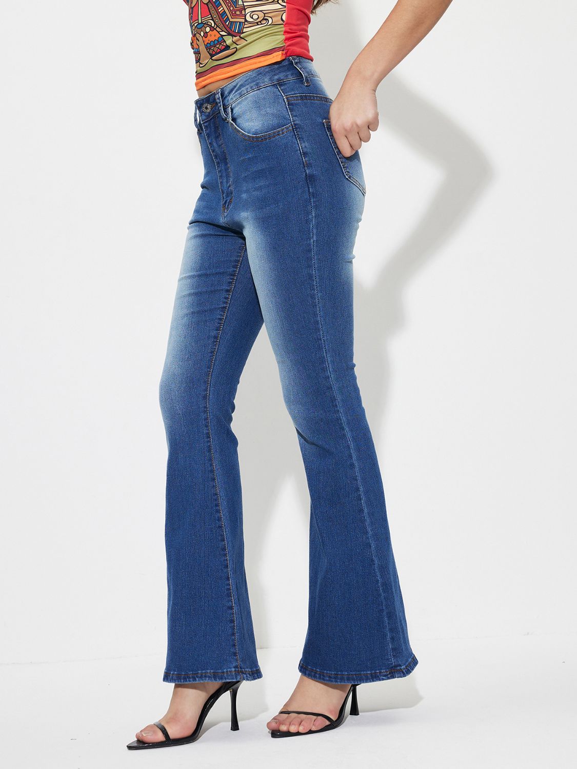 Mid-rise blue denim flare jeans with a buttoned closure and a faded wash.