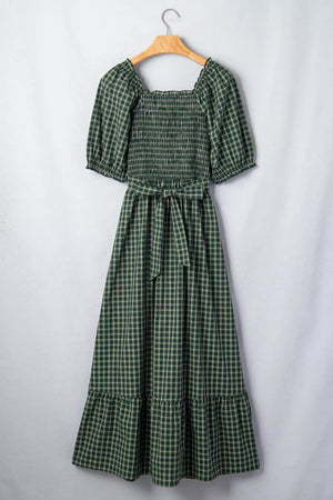 Plaid maxi dress with square neck, smocked bodice, puff sleeves, belted waist, and ruffled hem.