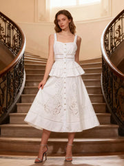 White eyelet embroidered midi dress with button front, tiered skirt, and cutout details.