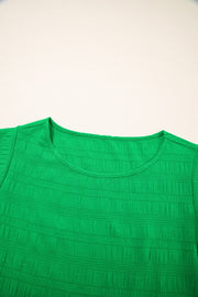Green crew neck blouse with textured fabric and ruffle sleeves