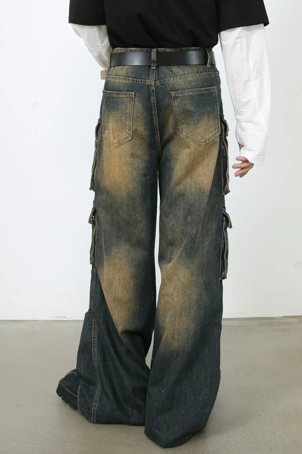 Distressed medium wash denim cargo pants with multiple pockets and a relaxed fit.