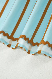 Light blue cotton blend blouse with brown stripes and scalloped hem detail.